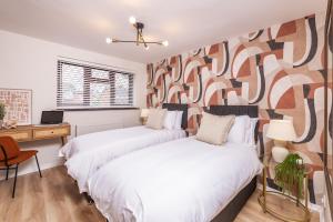 two beds in a room with a wall mural at Central Birmingham Luxury House, Sleeps 6 people - 10 mins from Solihull NEC, JLR, BHX Airport, Resorts World in Birmingham