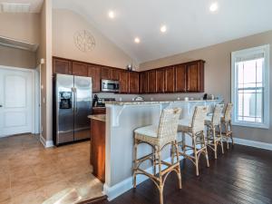 a kitchen with a bar with stools at Sundancer in Surf City