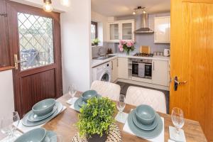 a dining room with a table and a kitchen at Central Birmingham Luxury House, Sleeps 6 people - 10 mins from Solihull NEC, JLR, BHX Airport, Resorts World in Birmingham