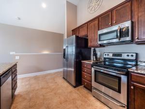 a kitchen with stainless steel appliances and wooden cabinets at Sundancer in Surf City