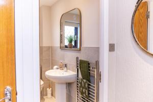 a bathroom with a sink and a mirror at Central Birmingham Luxury House, Sleeps 6 people - 10 mins from Solihull NEC, JLR, BHX Airport, Resorts World in Birmingham