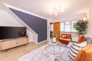 a living room with a couch and a tv at Central Birmingham Luxury House, Sleeps 6 people - 10 mins from Solihull NEC, JLR, BHX Airport, Resorts World in Birmingham