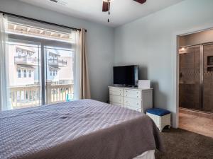 a bedroom with a bed and a television and a window at Sundancer in Surf City