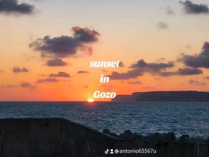 a sunset in the ocean with the words sunset in crore at Il figolla farmhouse in Xagħra