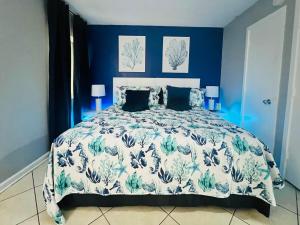 ein blaues Schlafzimmer mit einem Bett mit einer blauen und weißen Bettdecke in der Unterkunft Oceanfront 2BR King Suite Atlantica Resort in Myrtle Beach