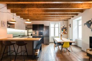 a kitchen with wooden ceilings and a table and chairs at Casa Riberi Mole Antonelliana Centro in Turin +9 photos