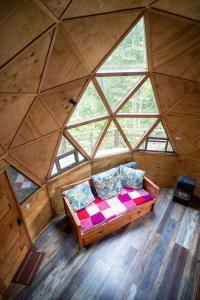 a bed in a room with a large window at Hermoso domo en altura entre el bosque nativo + tinaja privada in Licán Ray