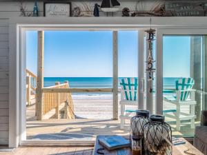 een woonkamer met uitzicht op het strand bij Vintage Vacation in Surf City