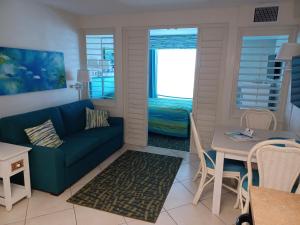 Islander Beach Resort - New Smyrna Beach في نيو سميرنا بيتش: غرفة معيشة مع أريكة وطاولة