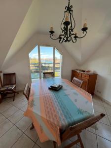 a dining room with a table and a chandelier at lambezen Notinau, vue mer, plages à proximité in Camaret-sur-Mer