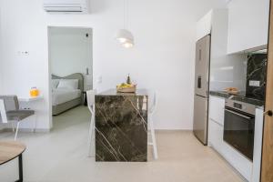 a kitchen with white walls and a marble counter at Sardines Luxury Suites in Hersonissos
