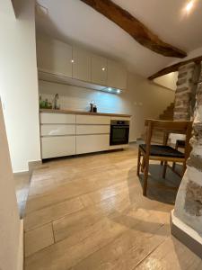a kitchen with white cabinets and a wooden floor at Zofia appartements - Appartement avec cour privée #1 in Moustiers-Sainte-Marie +14 photos