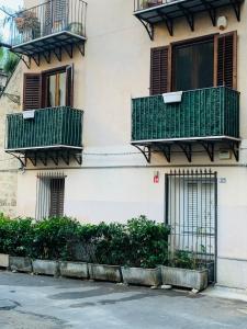 a building with green balconies on the side of it at Cathedral House in Palermo
