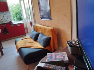 a living room with a couch with a blanket on it at Accueil curistes et Thermes climatisé in Montrond-les-Bains