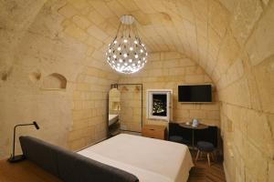 a room with a bed and a chandelier at La Corte Dei Pastori in Matera