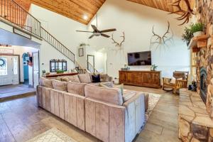 a living room with a large couch and a ceiling fan at Near Woodland Lake Park Cabin with Serene Deck! in Pinetop-Lakeside