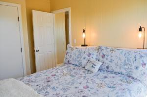 a bedroom with a bed with a floral bedspread and a pillow at Sunray Cottage in Surf City +30 photos