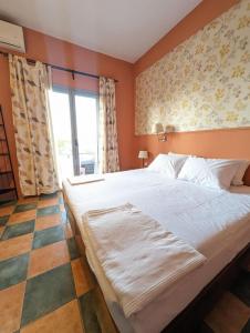 a bedroom with a large bed and a window at Okeania Seafront Rooms in Kamena Vourla in Kamena Vourla