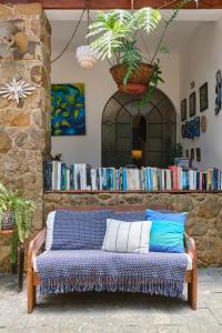 un sofá en una habitación con una estantería con libros en Pousada Pontal Gardens en Parati