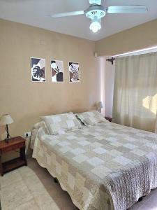 a bedroom with a bed and pictures on the wall at Resolana in Valeria del Mar