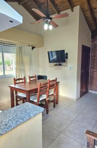 a dining room with a wooden table and a flat screen tv at Resolana in Valeria del Mar