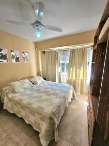 a bedroom with a bed and a ceiling fan at Resolana in Valeria del Mar