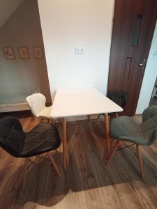 a white table and two chairs in a room at Blisko Energylandii in Zator
