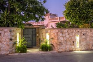 a house with a stone fence and a stone wall at Niko's art Villa in Chania in Perivólia