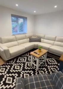 a living room with a couch and a table at Private luxurious apartment in Easthampstead