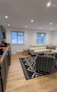 a living room with a couch and a kitchen at Private luxurious apartment in Easthampstead