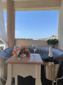 a table with two glasses and a bottle of wine at Grand Villa Katerina in Ierápetra
