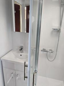 ein weißes Badezimmer mit Waschbecken und Dusche in der Unterkunft L&g FAMILY HOLIDAYS 6 BERTH CORAL BEACH LAURA FAMILYS ONLY AND LEAD PERSON MUST BE OVER 30 in Ingoldmells