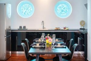 stół z krzesłami i niebieski stół oraz kuchnia w obiekcie 1BD Serene Calm Pool House w Atenach