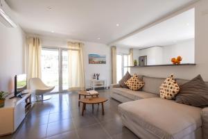 uma sala de estar com um sofá e uma TV em Carmona A T2 - By Smarthomes em São Martinho do Porto mais 51 fotografias