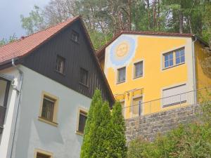 a yellow and white building with a clock on it at Villa Sonnenblick in Kurort Rathen