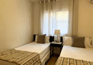 zwei Betten in einem Zimmer mit Fenster in der Unterkunft Sweet BCN Laforja in Barcelona
