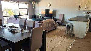 a living room with a couch and a table at Just Breezy - Visit Langebaan in Langebaan