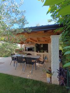 a patio with a table and chairs under a pergola at Apartman Ika Umag in Umag +16 photos