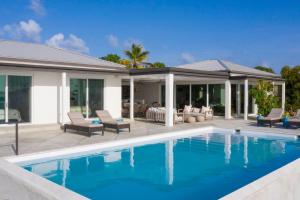a swimming pool in front of a house at Tropical Panorama in Cruz Bay