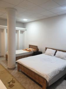 a bedroom with two beds and a pillar at Eni Rooms 2 in Ohrid