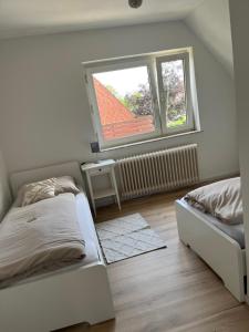 a bedroom with two beds and a window at Ferienwohnung Hygge in Friedrichstadt