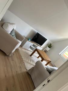 a living room with a couch and a tv at Ferienwohnung Hygge in Friedrichstadt