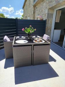 a table with a vase of flowers on a patio at Petite maison in Plouguerneau +5 photos