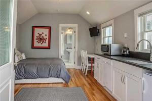Un pequeño dormitorio con una cama y una cocina. en The Ladybug by Seabrook Hospitality, en Pacific Beach