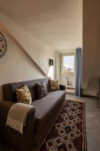 sala de estar con sofá y ventana en Alloggio Torino InQuadro en Turín