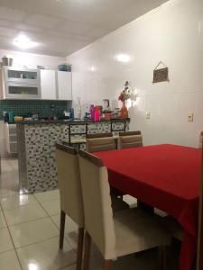 eine Küche und ein Esszimmer mit einem roten Tisch und Stühlen in der Unterkunft Casa da Mari in Petrolina