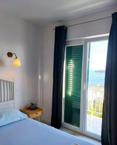 Un dormitorio con una ventana con vista al mar. en NatasaHvar, en Hvar