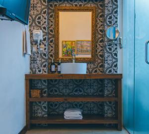 a bathroom with a sink and a mirror on a wall at Hotel Boutique Casa Altamira in Querétaro