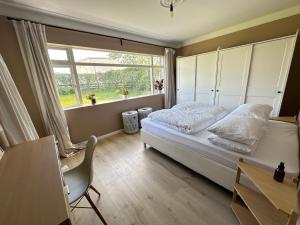 - une chambre avec un lit, une fenêtre et un bureau dans l'établissement Apartment Rauðalækur - Birta Rentals, à Reykjavik