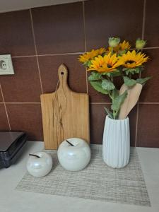a vase with flowers in it next to a cutting board at Angel Rooms in Yiofirákia